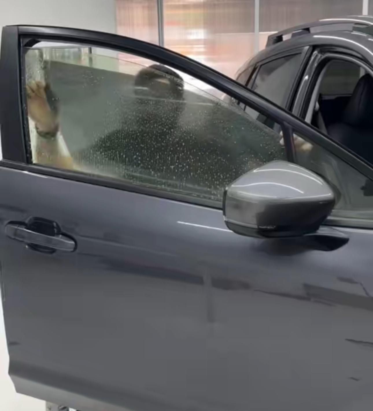 Una persona está sentada en un coche con la puerta abierta.