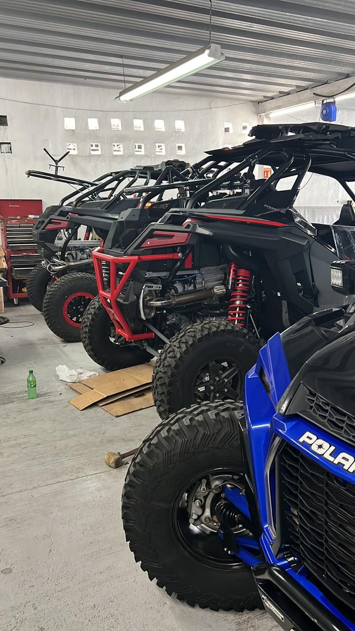 Una fila de vehículos todo terreno están estacionados en un garaje.