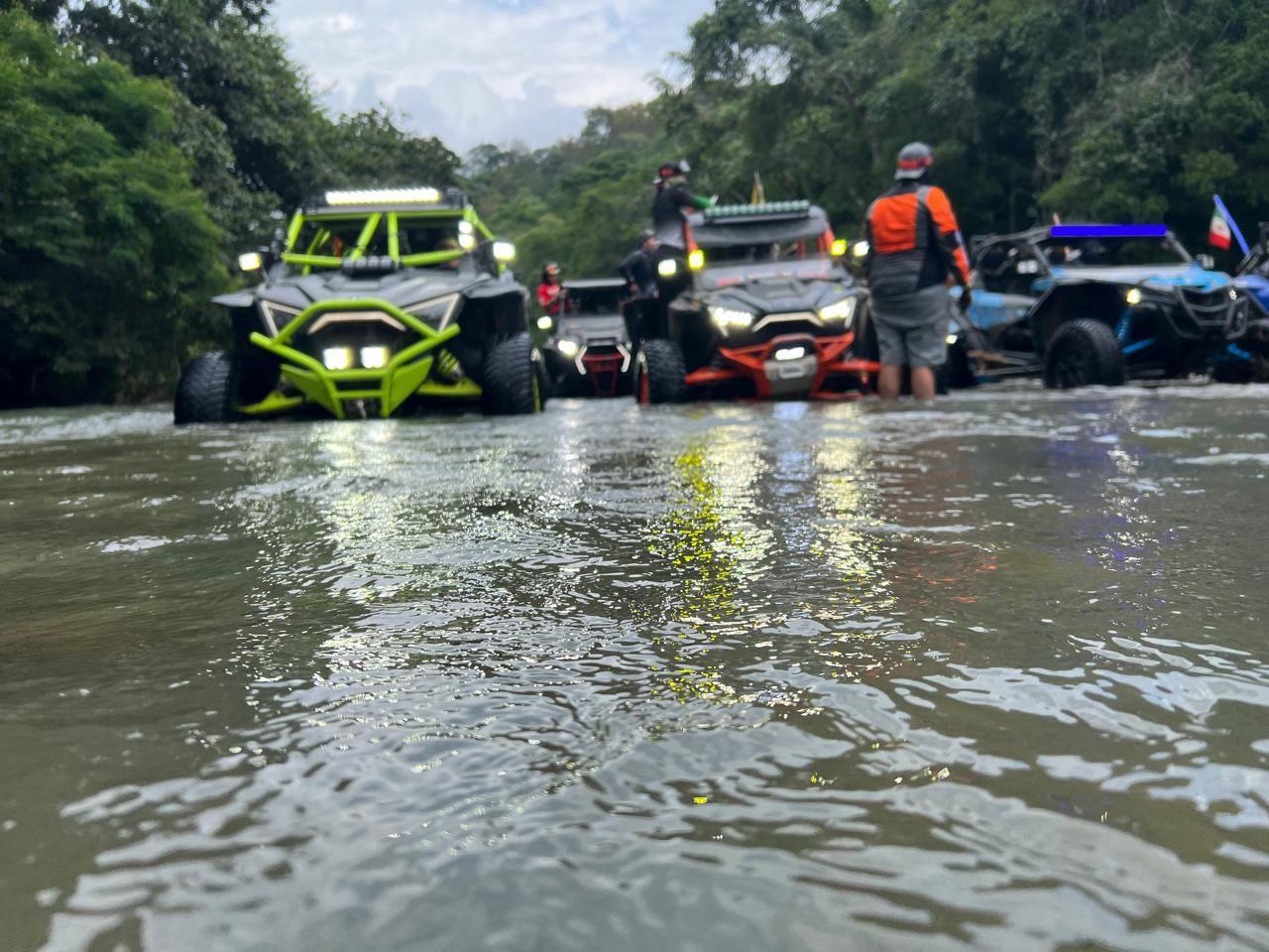 Un grupo de vehículos todo terreno circula por un río.