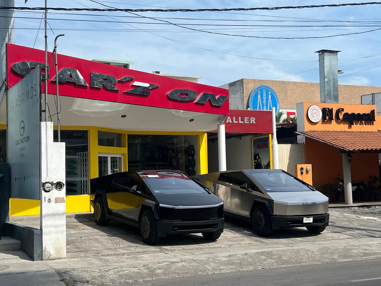 Dos coches Tesla están estacionados frente a un edificio.