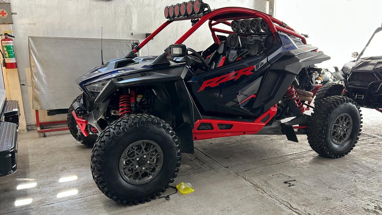 Un vehículo todo terreno rojo y negro está estacionado en un garaje.