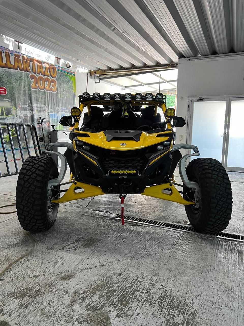 Un cochecito amarillo y negro está aparcado en un garaje.