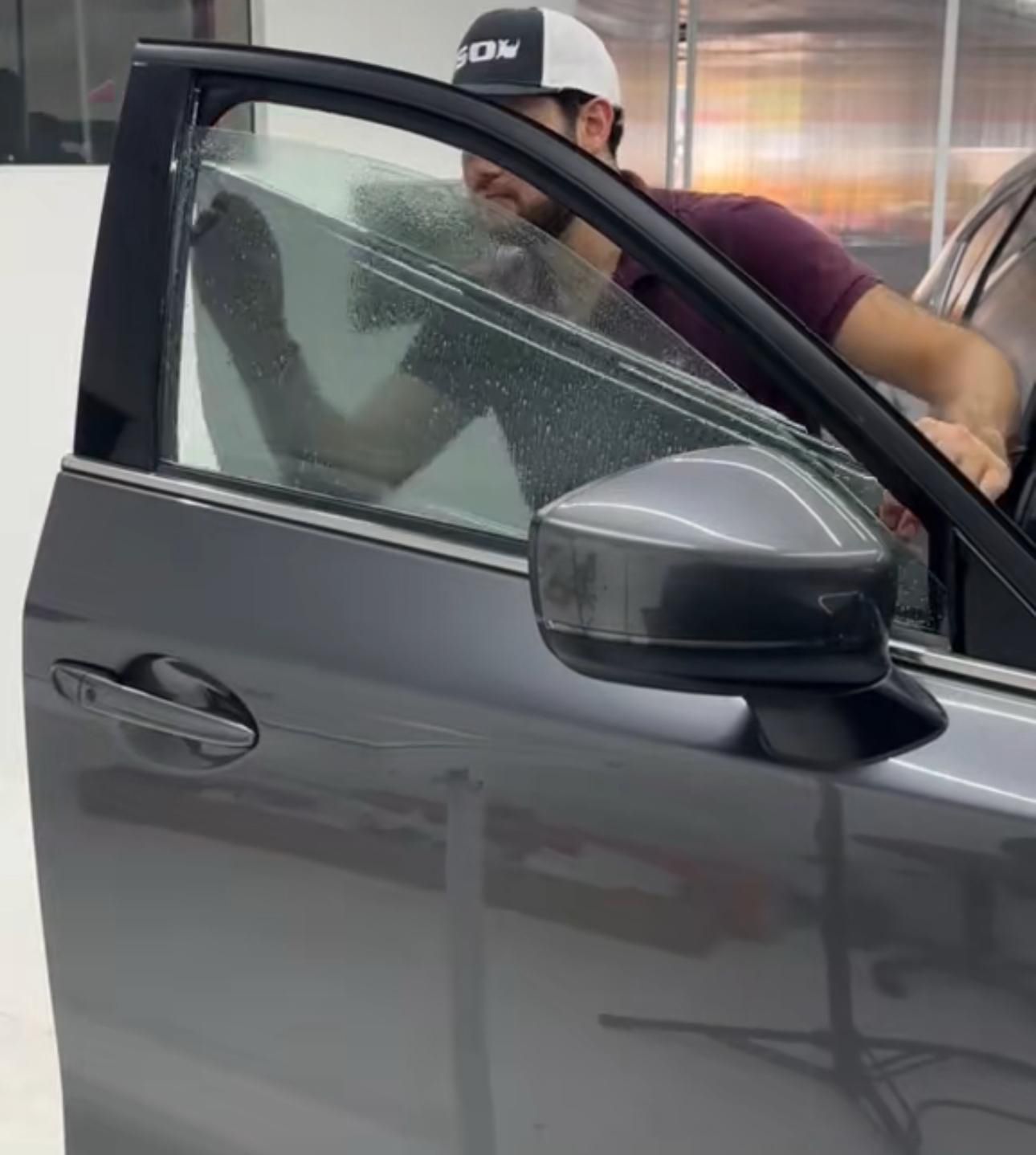 Un hombre con sombrero está sentado en un coche.