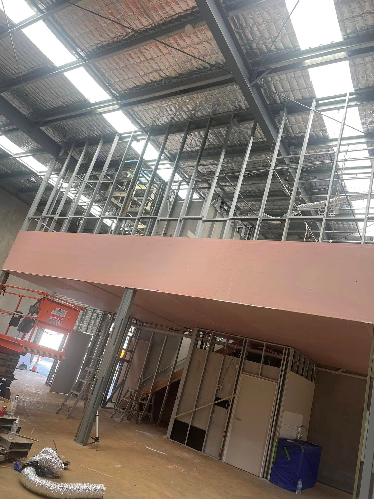 An Indoor Construction Site With A Mezzanine Level And Metal Wall Framing — HJK Plastering In South Lismore, NSW