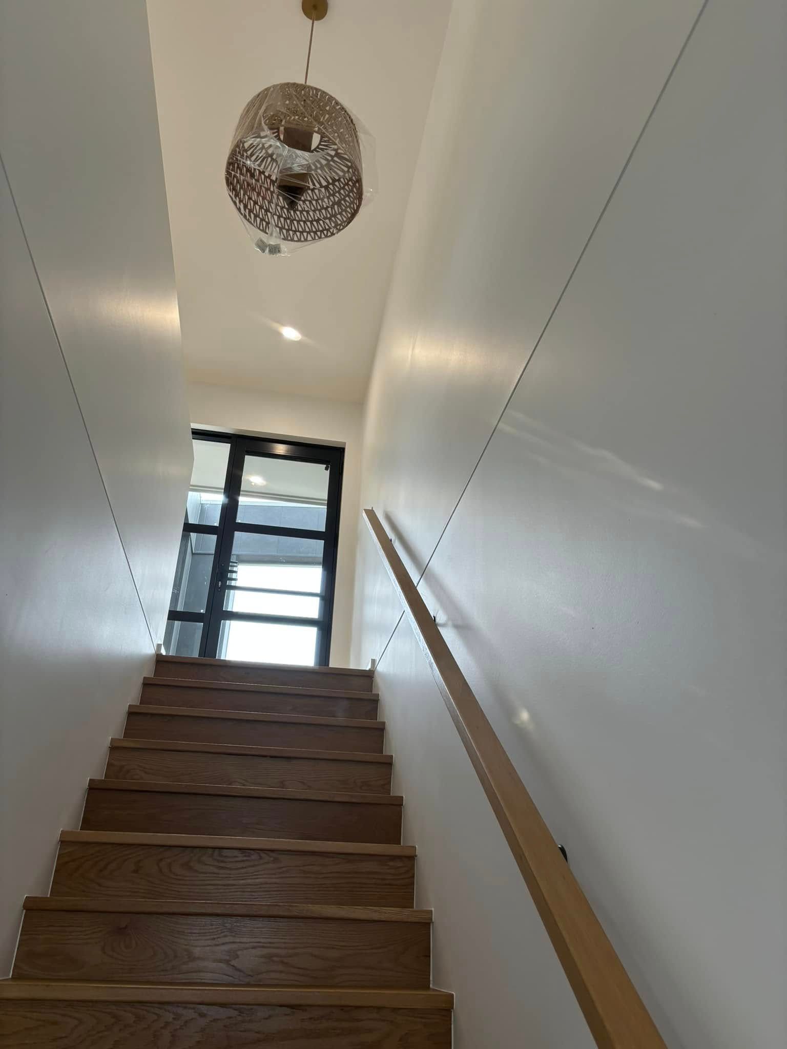 A Wooden Staircase Leads Upward Toward A Bright Doorway — HJK Plastering In South Lismore, NSW