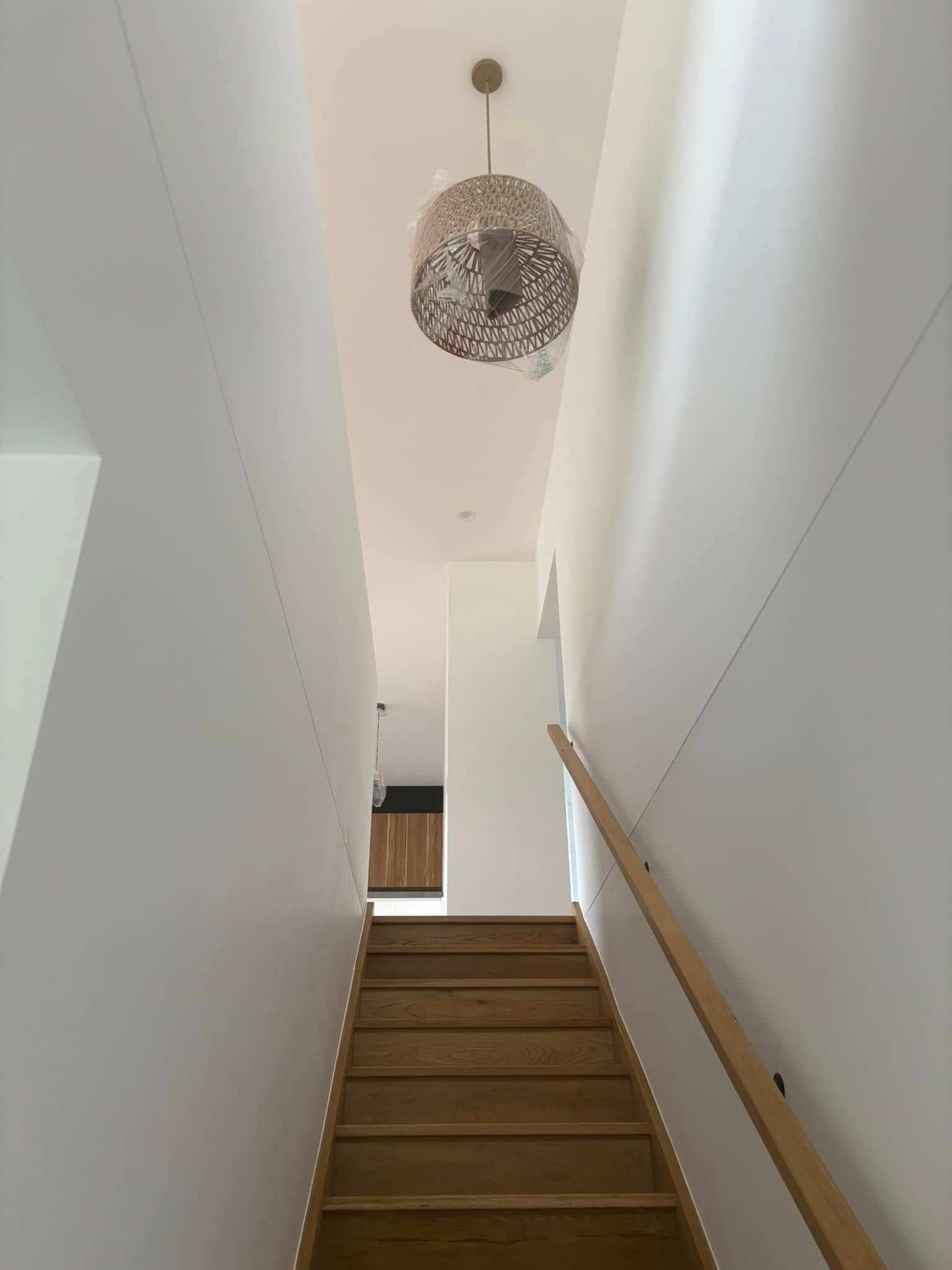 A Staircase Leads Upward Between Two Walls, Illuminated By A Spherical Pendant Light — HJK Plastering In South Lismore, NSW