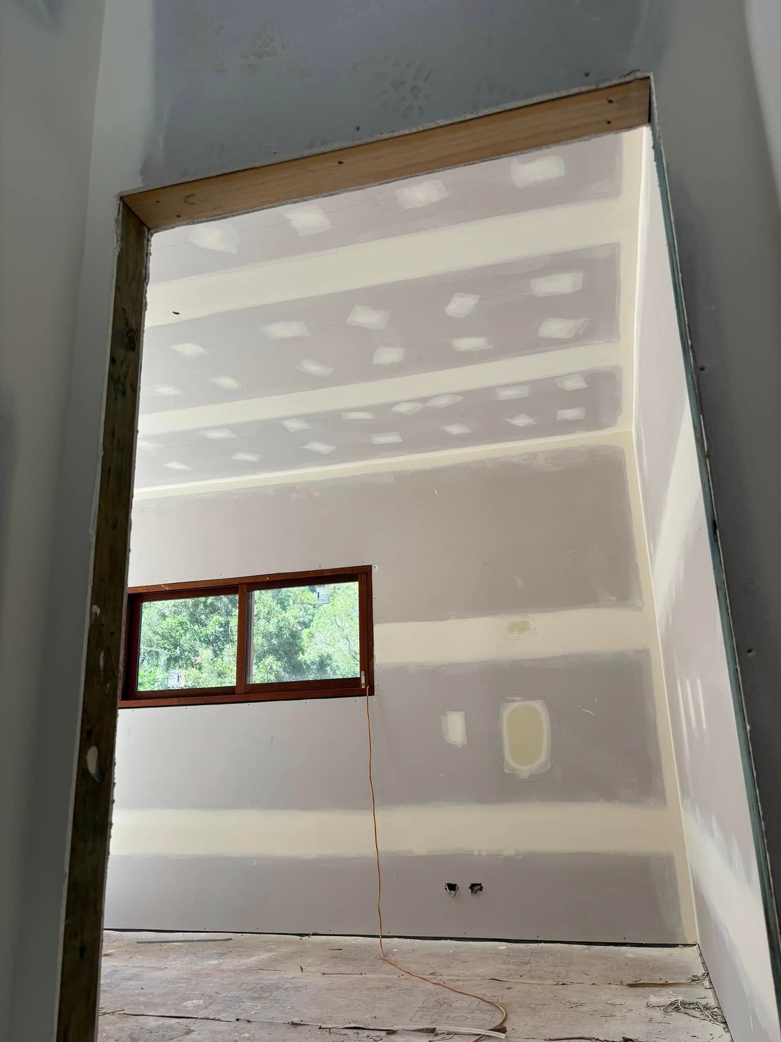 An Unfinished Room Viewed Through A Wooden Doorway — HJK Plastering In Ballina, NSW