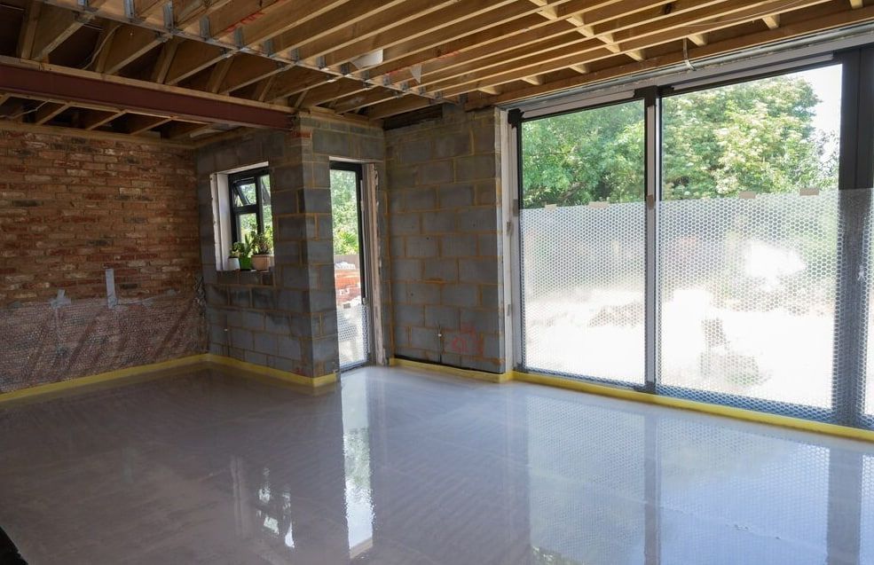 An Interior Construction Site With Glossy Tile Flooring And Exposed Ceiling Joists — HJK Plastering In Kyogle, NSW