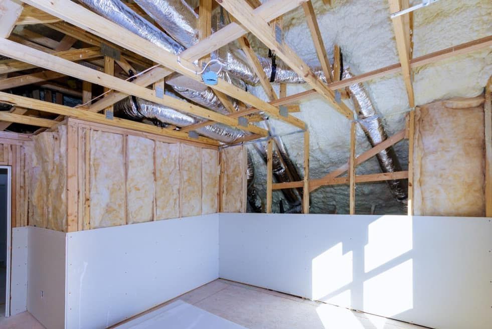 A Room Interior Featuring Exposed Wooden Rafters, Insulation, and Ductwork — HJK Plastering In South Lismore, NSW