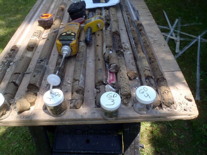 A wooden table with jars of soil and tools on it