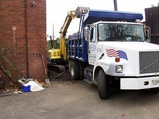 A dump truck is parked in front of a brick building