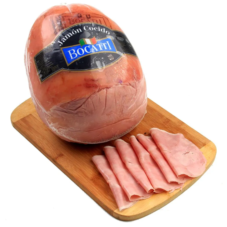 Un gran trozo de jamón bocati reposa sobre una tabla de cortar de madera.