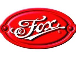 Logotipo de caramelo Fox ovalado rojo con texto en escritura blanca.