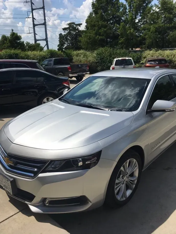 A silver car is parked in a parking lot.