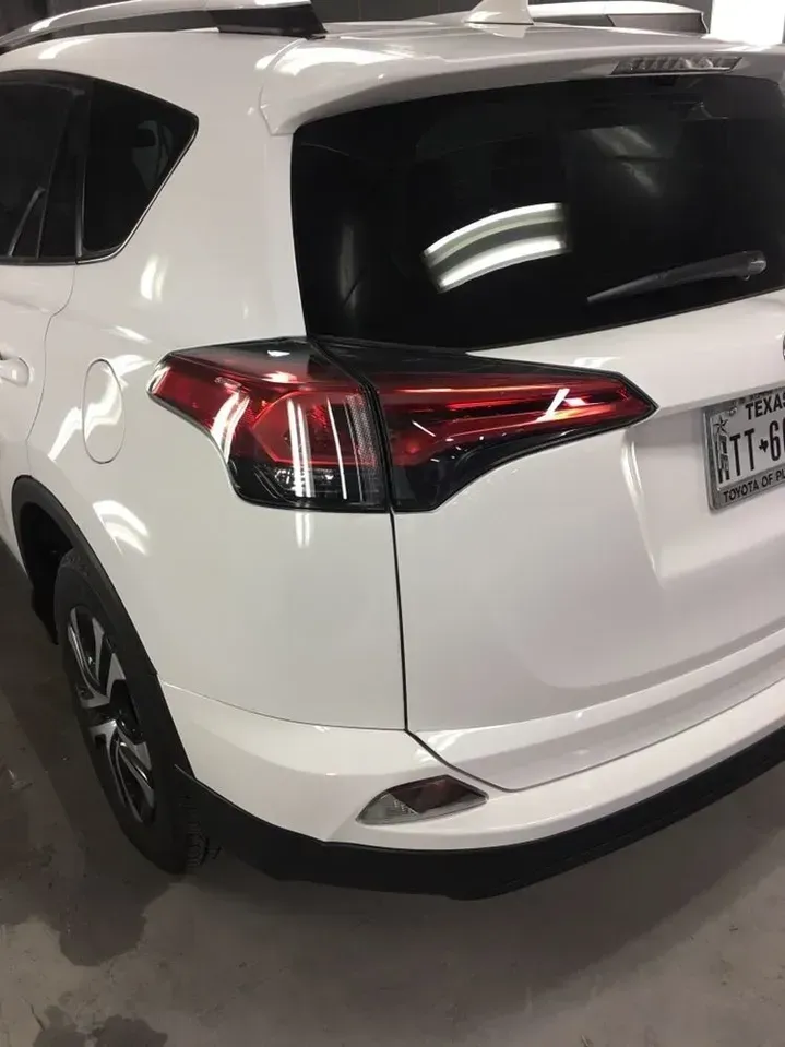 A white toyota rav4 is parked in a garage.