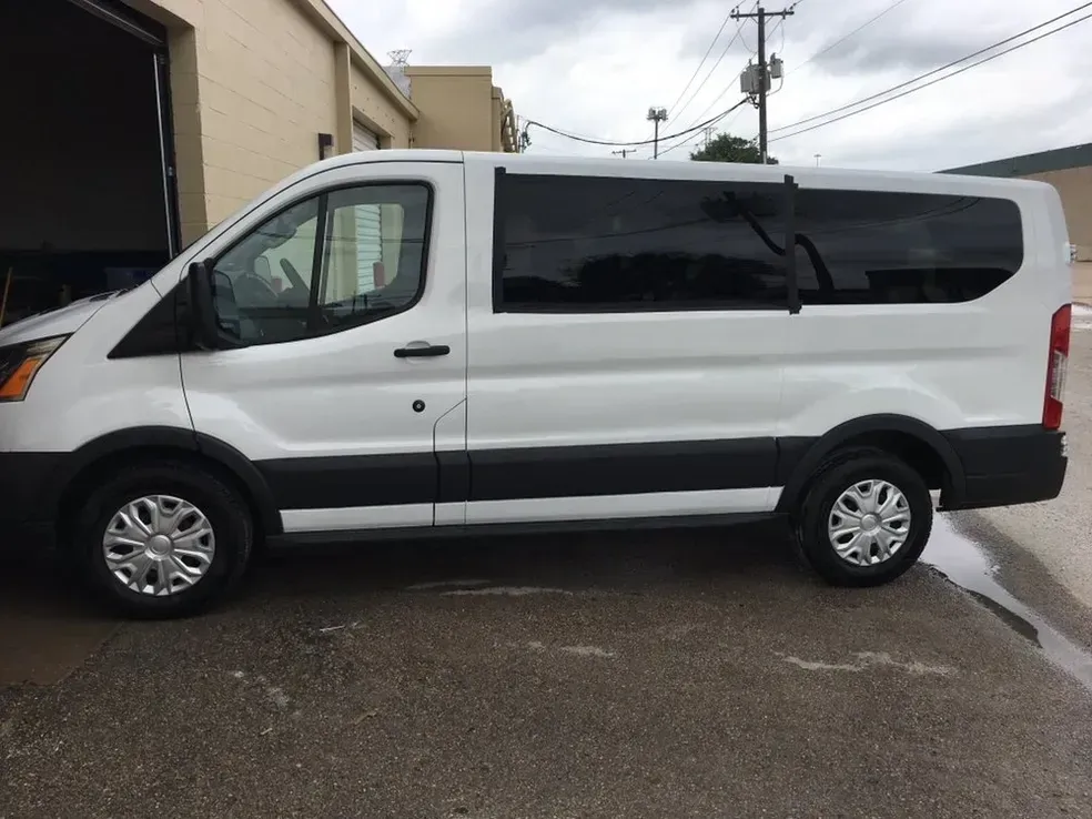 A white van is parked in front of a building.