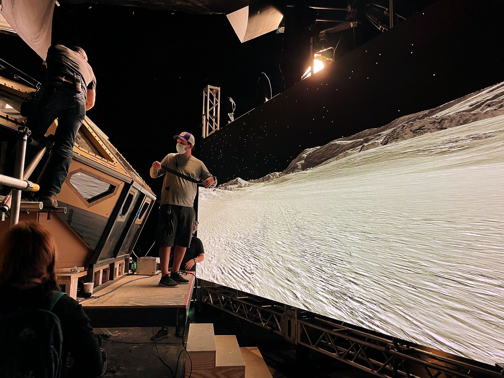 A group of people standing in front of a large screen