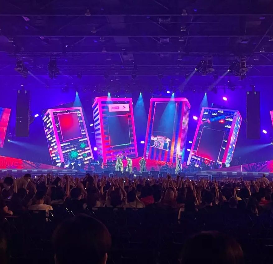 A crowd of people are watching a concert in a stadium