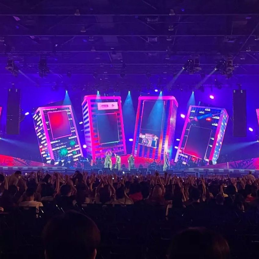 A crowd of people are watching a concert in a stadium.