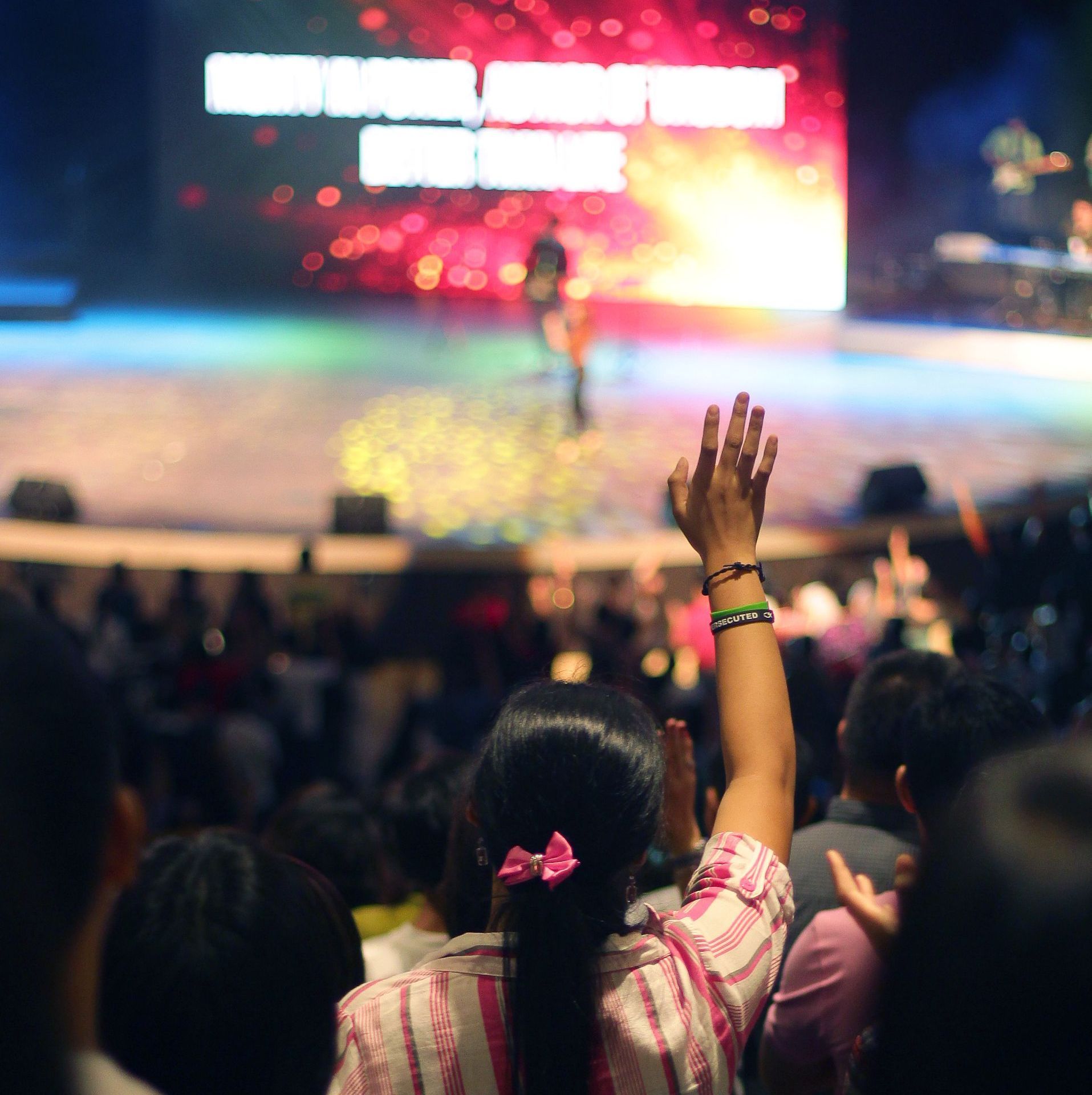 A woman holds her hand up in the air at a concert