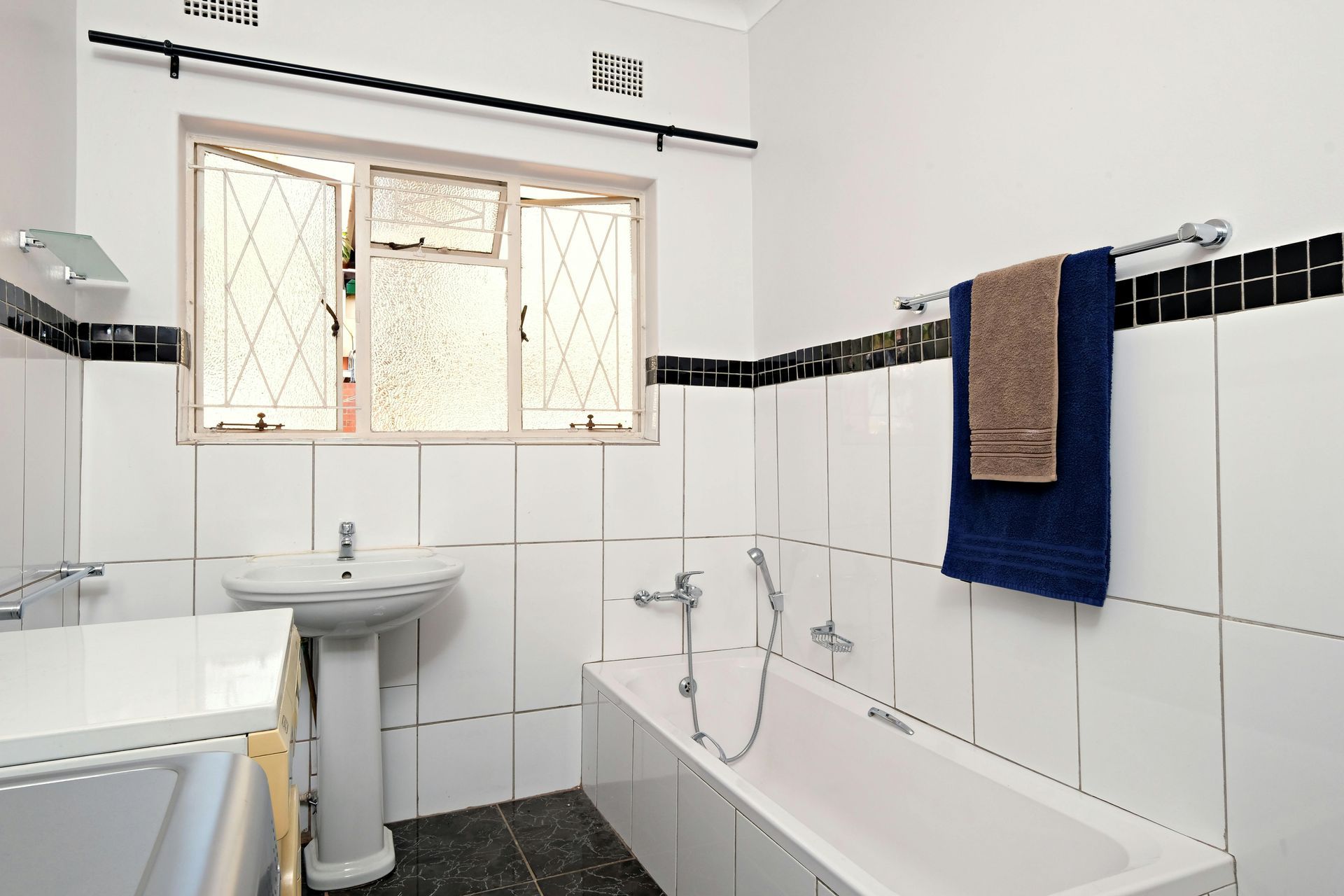 A bathroom with a bathtub a sink and a window