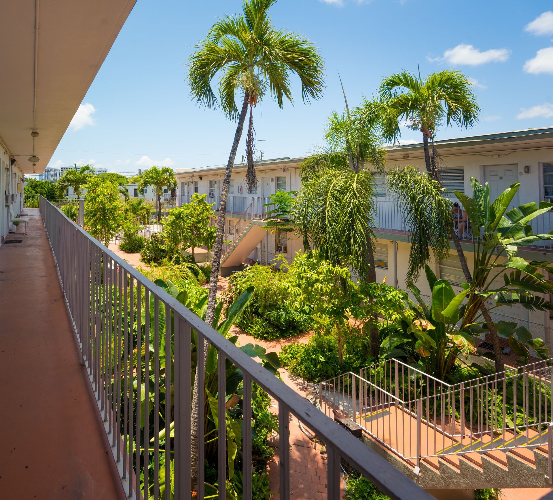 A balcony overlooking a building with palm trees