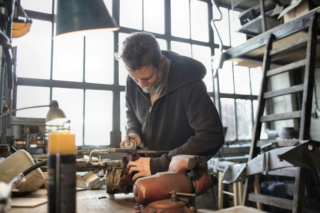 A man is working on a machine in a workshop.
