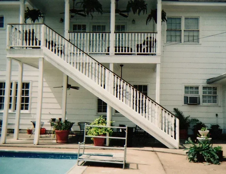 A white house with stairs leading up to the second floor