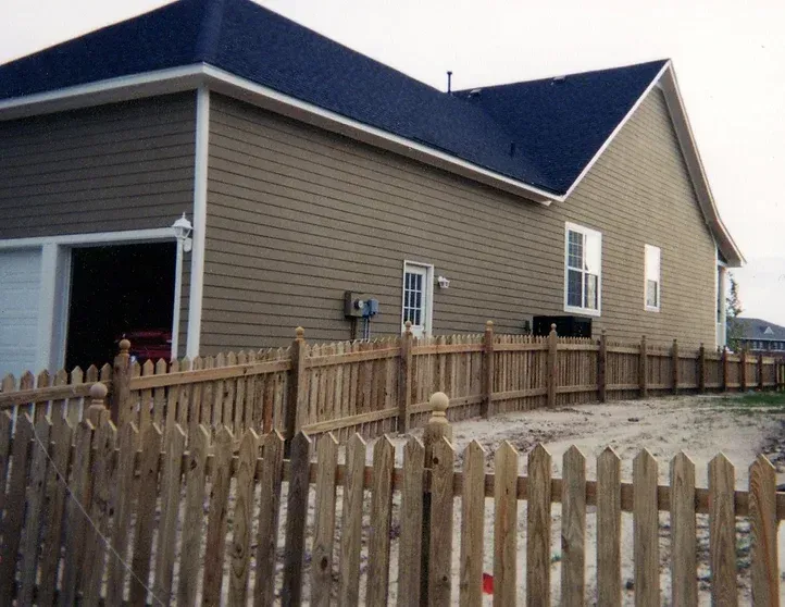 A house with a wooden picket fence in front of it