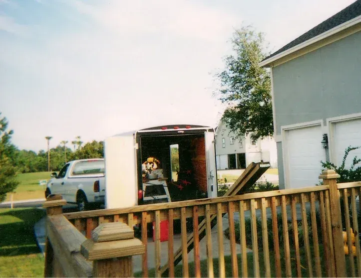 A truck and trailer are parked in front of a house