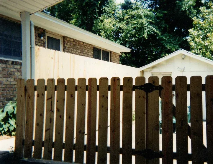 A wooden fence is in front of a house