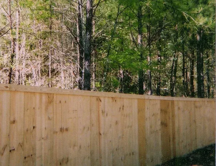 A wooden fence with trees in the background