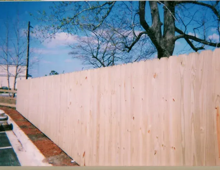 A wooden fence with a tree in the background