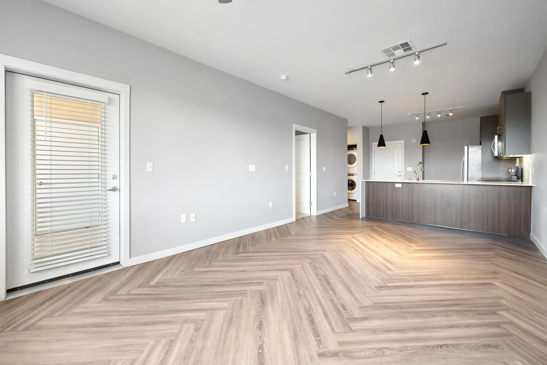Open-concept living area with a modern kitchen island and a laundry closet.
