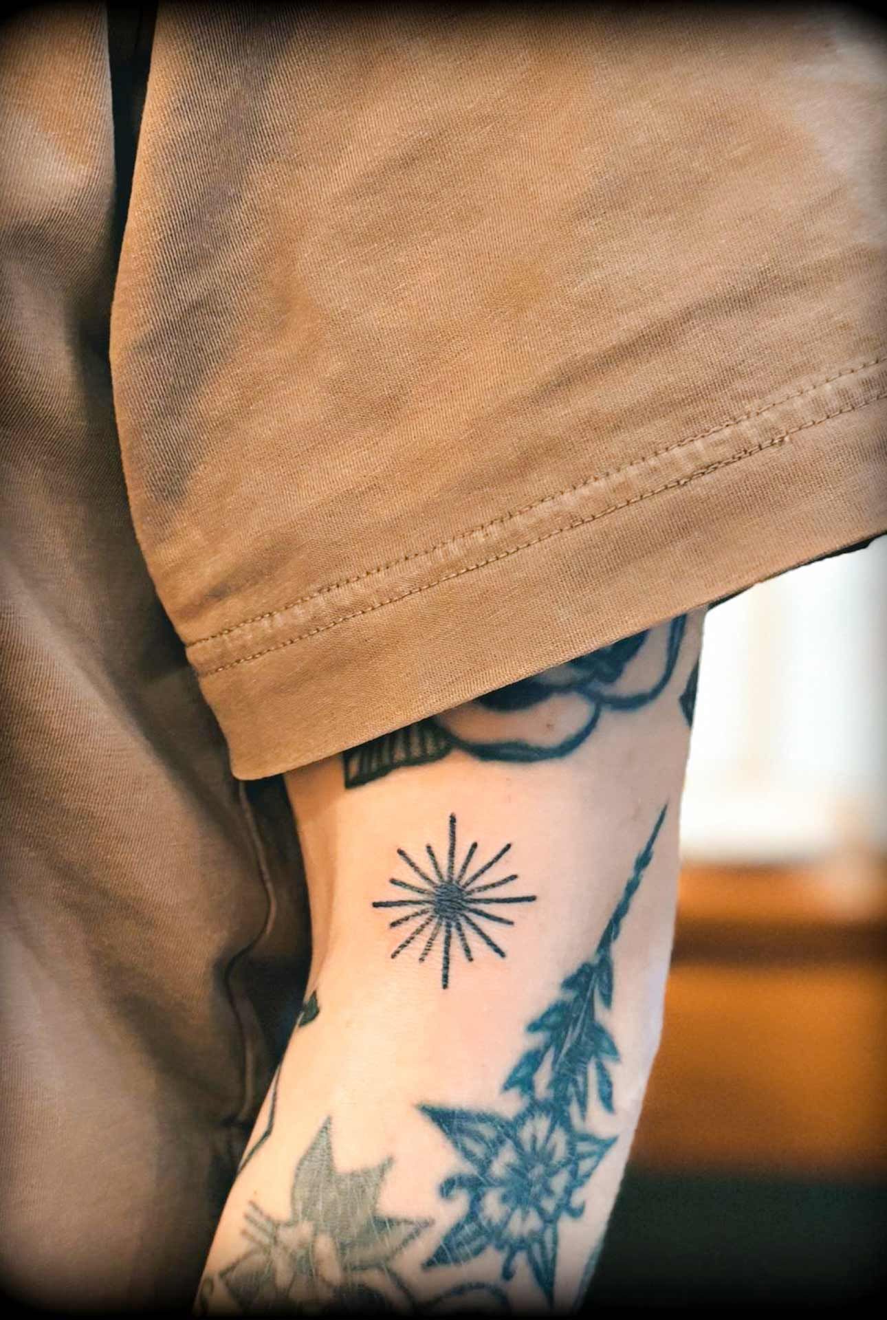 Un gros plan du bras d'une personne avec des tatouages dessus.
