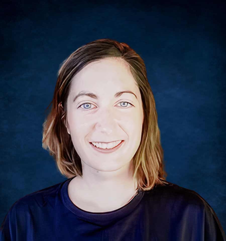 Une femme en chemise bleue sourit à la caméra.