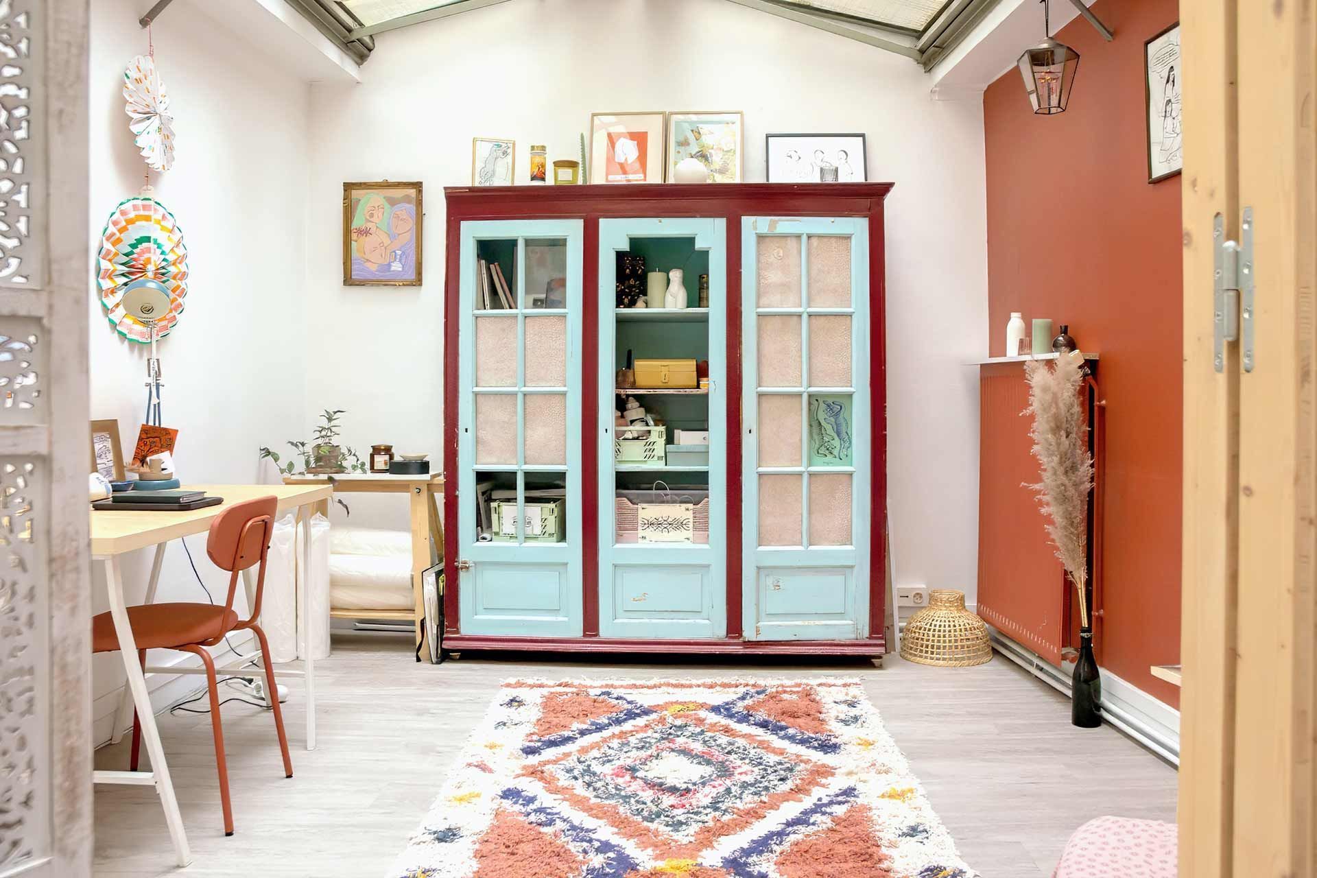 Une pièce avec un tapis, des chaises, une table et une armoire.