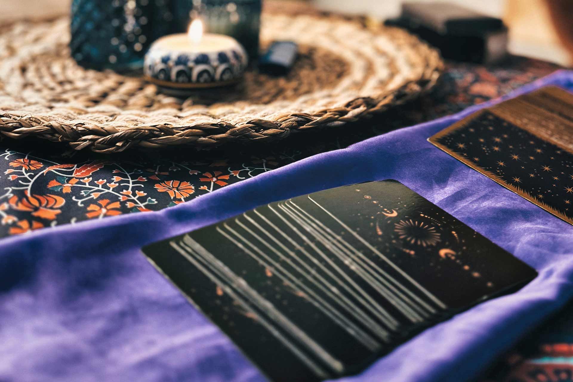 Un gros plan d'une carte de tarot sur un tissu violet sur une table.