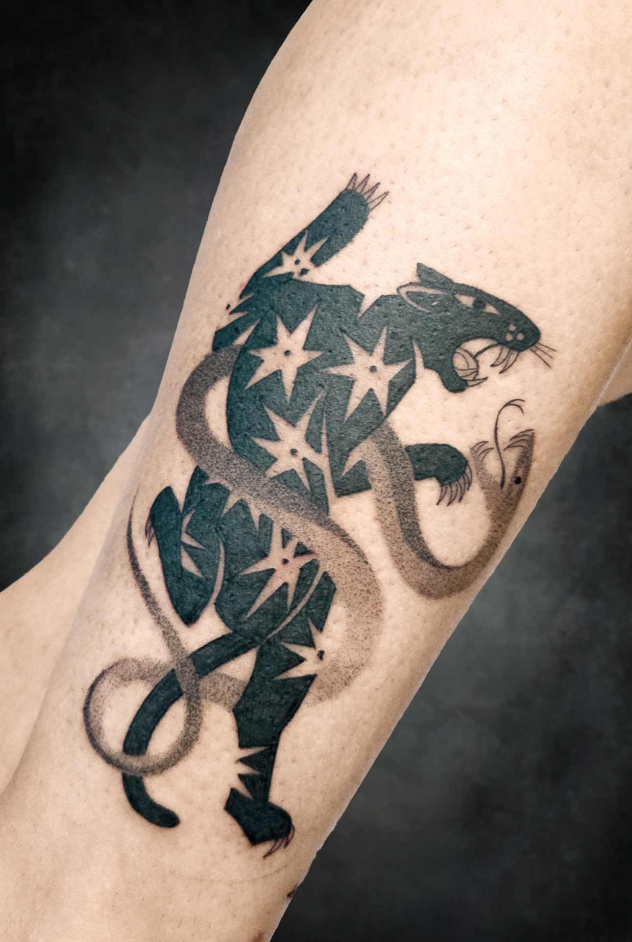 Un tatouage d'une panthère avec des étoiles sur son corps