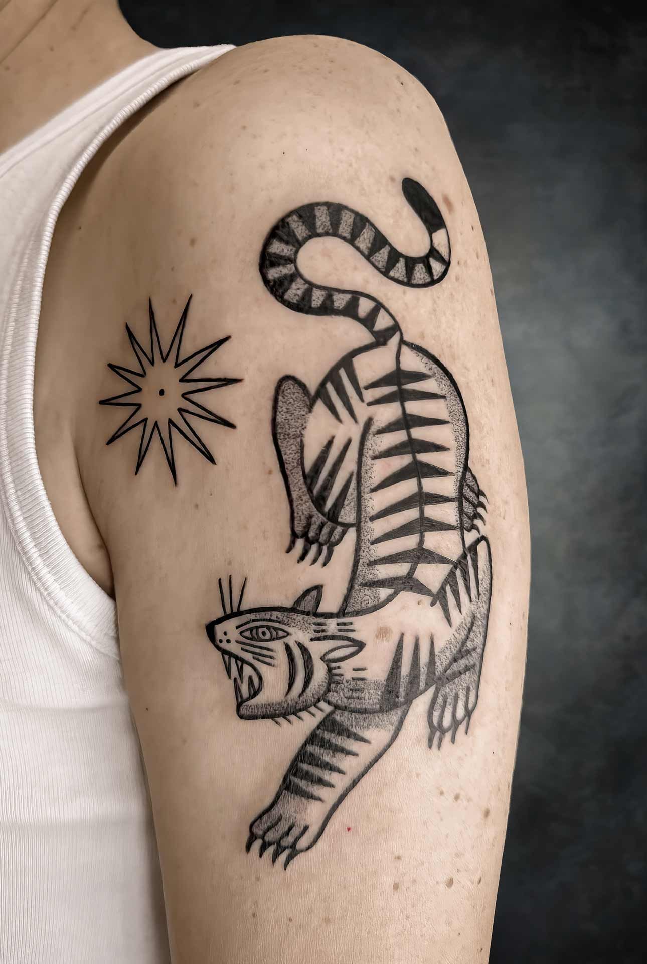 Une personne a un tatouage de tigre sur le bras