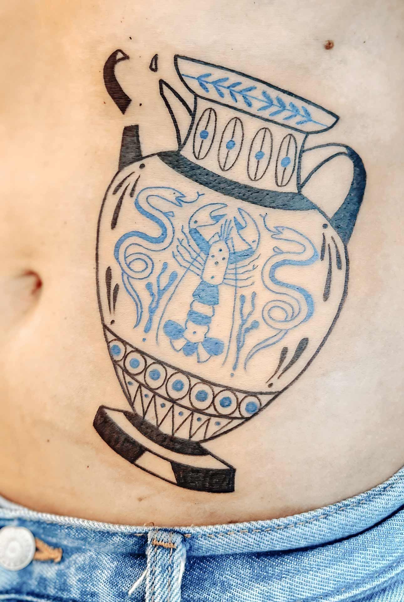 Une femme a un tatouage d'un vase sur le ventre