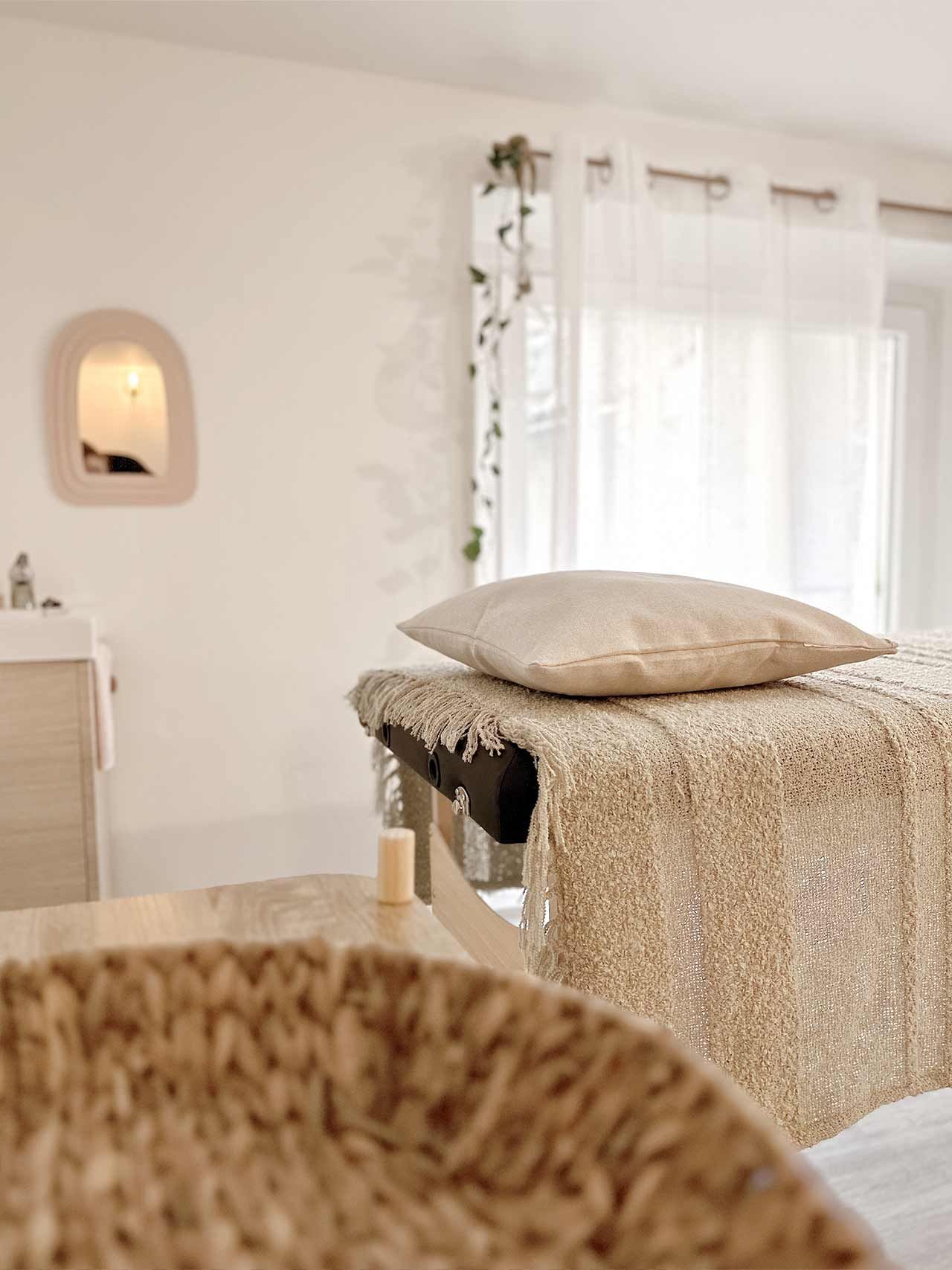 Une table de massage avec un oreiller dessus dans une pièce.