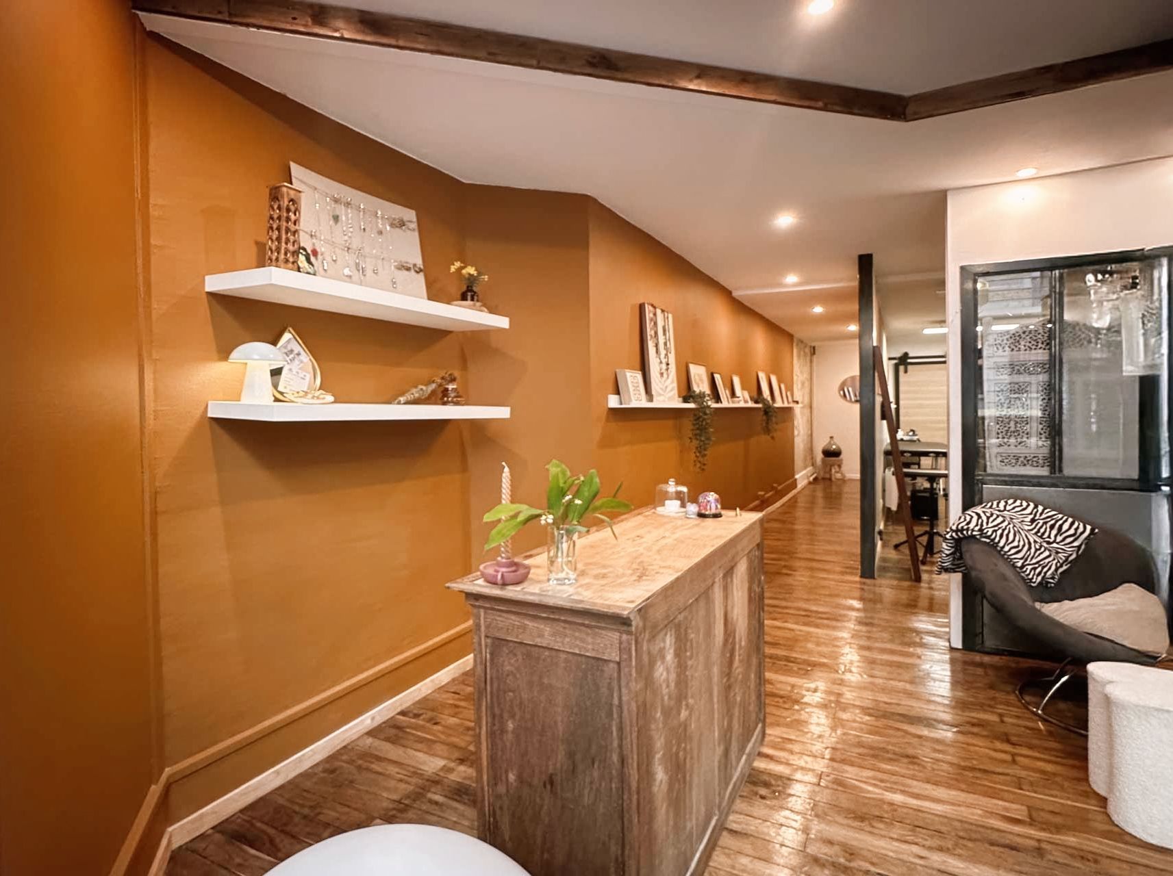 Un salon avec un parquet, des chaises, une table et une fenêtre.