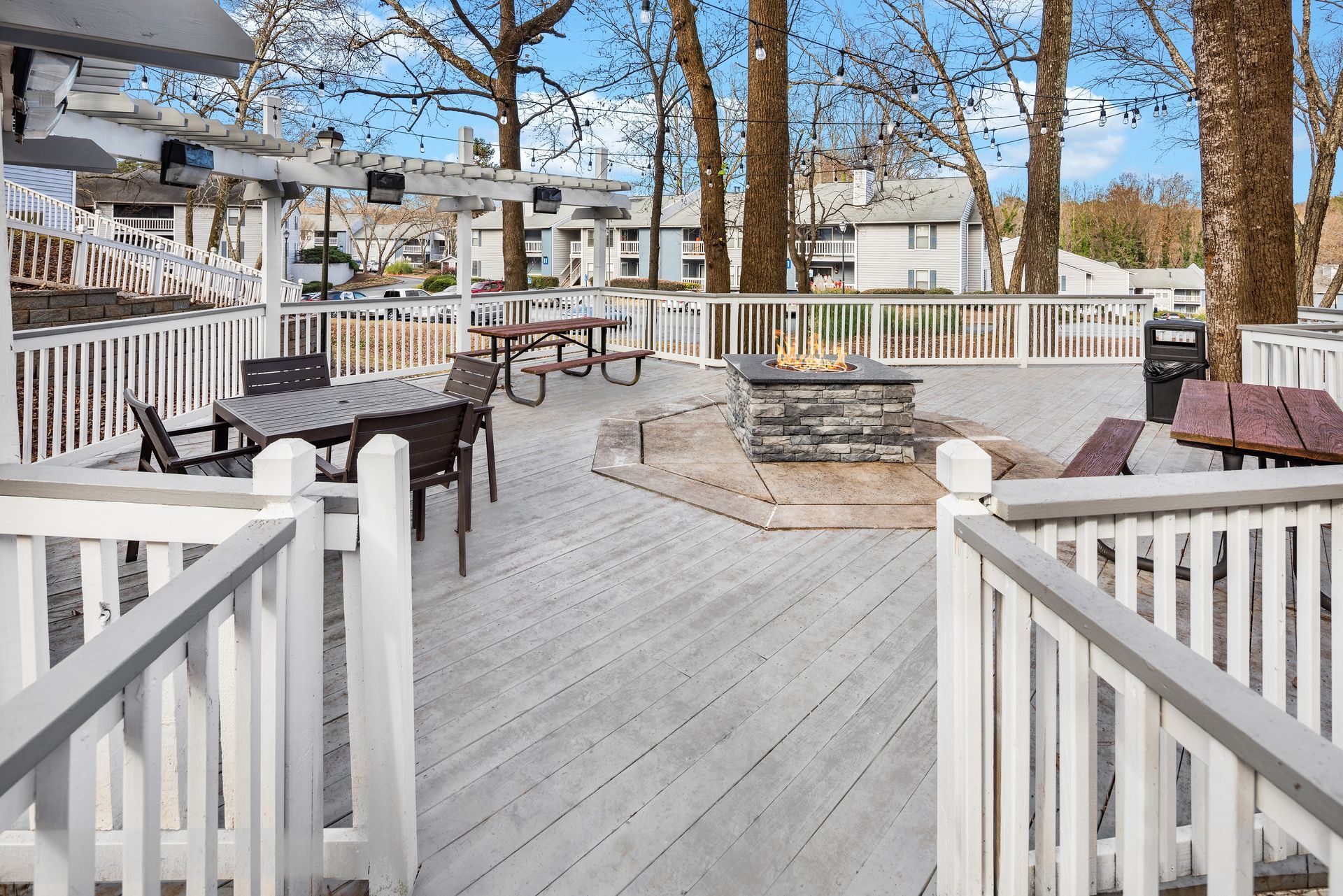 Outdoor deck with seating areas, a fire pit, and a picnic table.
