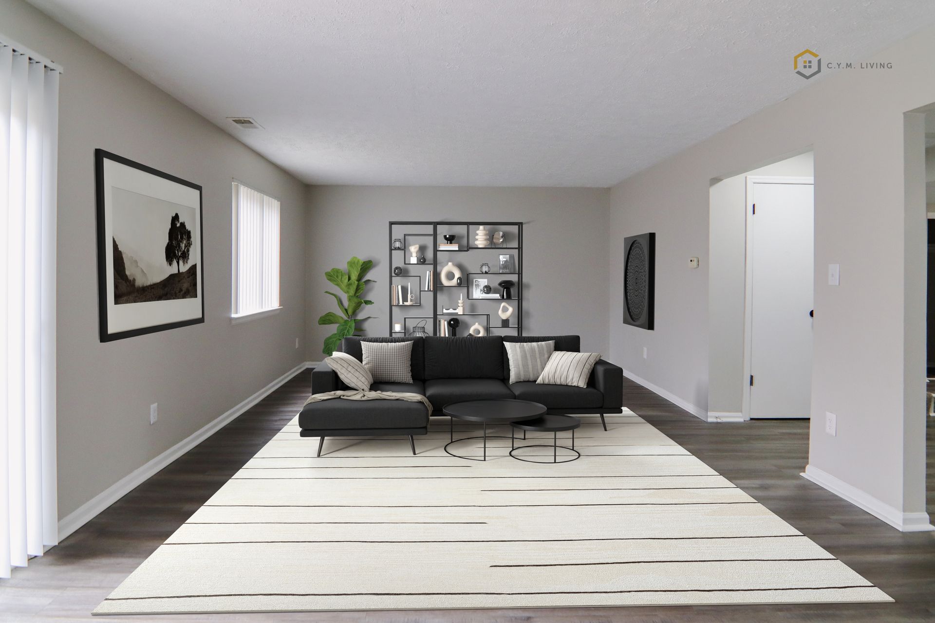 Living room with black sofa, gray walls, and a white rug with dark stripes.