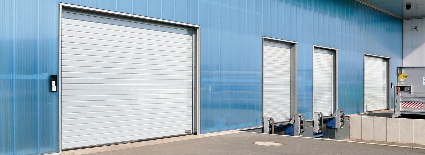 Exterior of a loading dock with large doors in a blue warehouse.