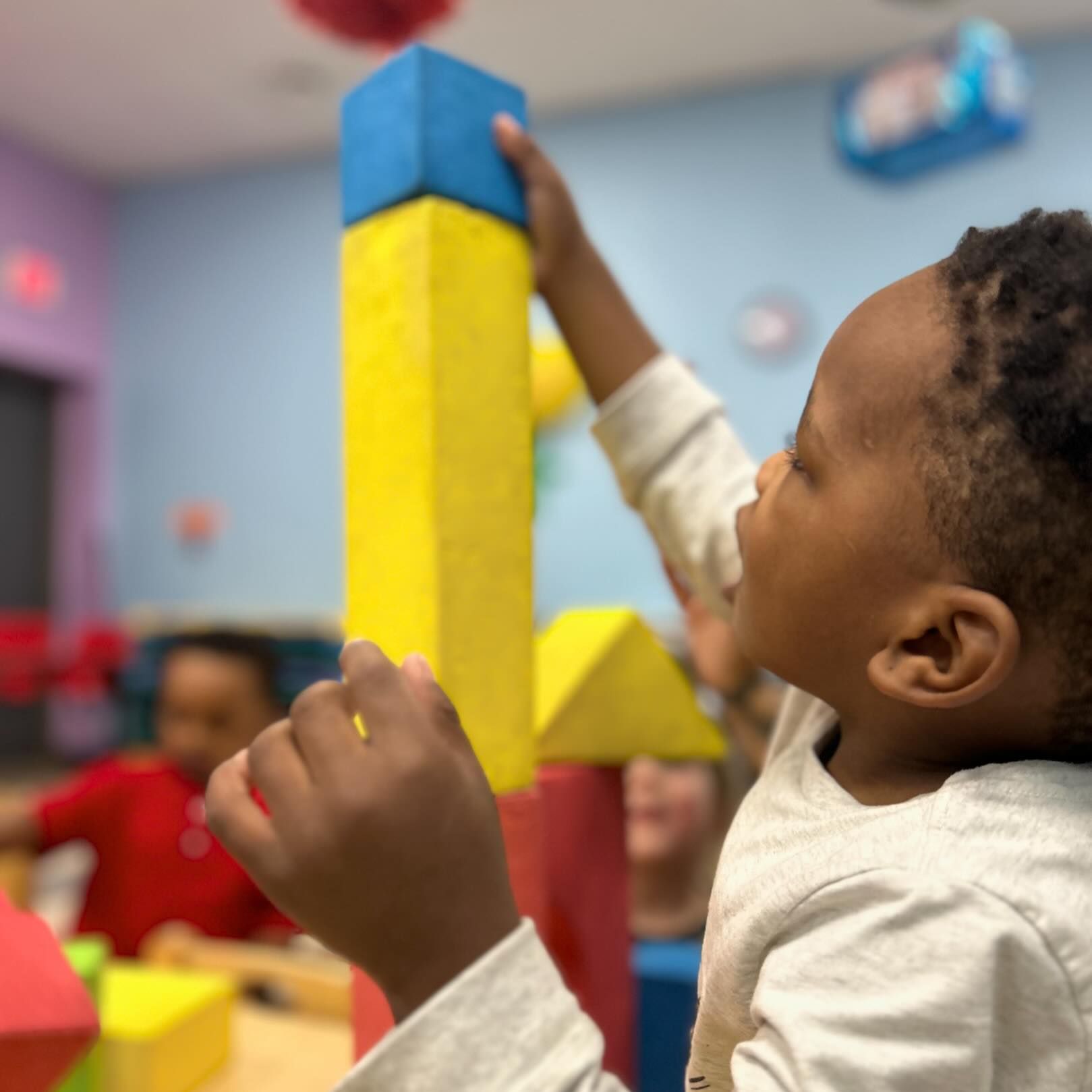 A young boy is playing with colorful blocks in a room