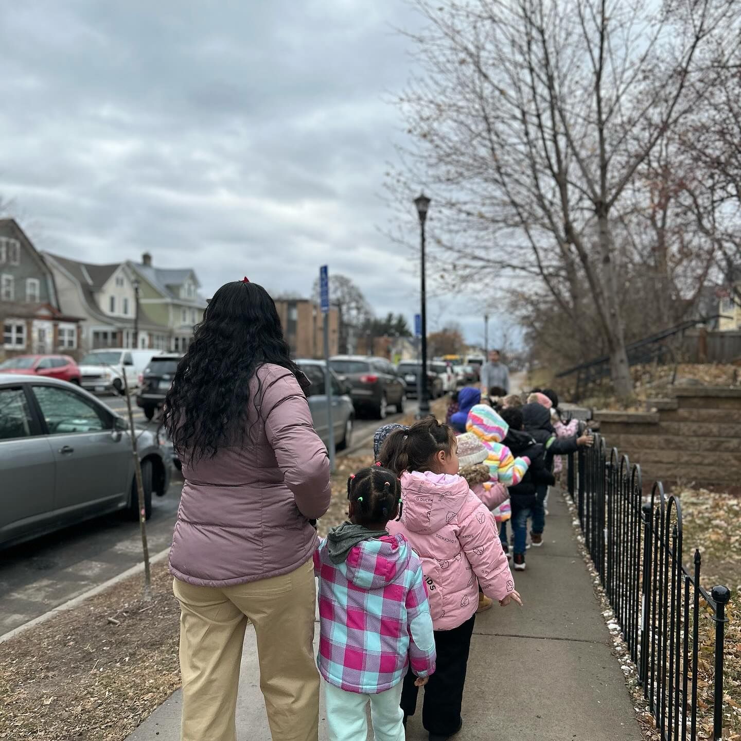 A group of children are walking down a sidewalk.