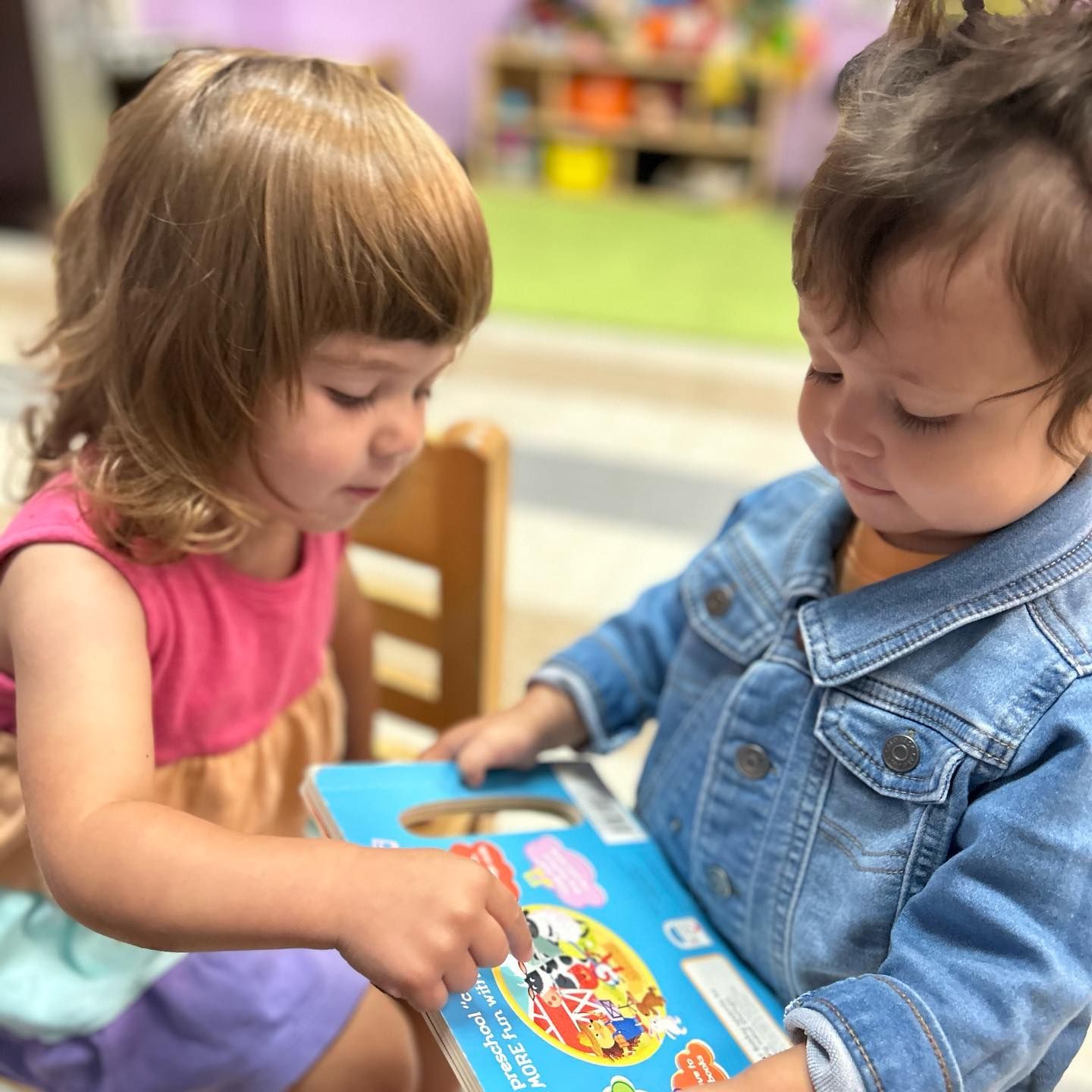A boy and a girl are reading a book together