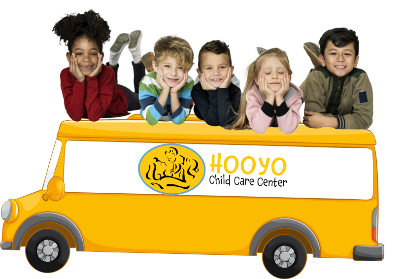 A group of children are laying on top of a yellow bus.